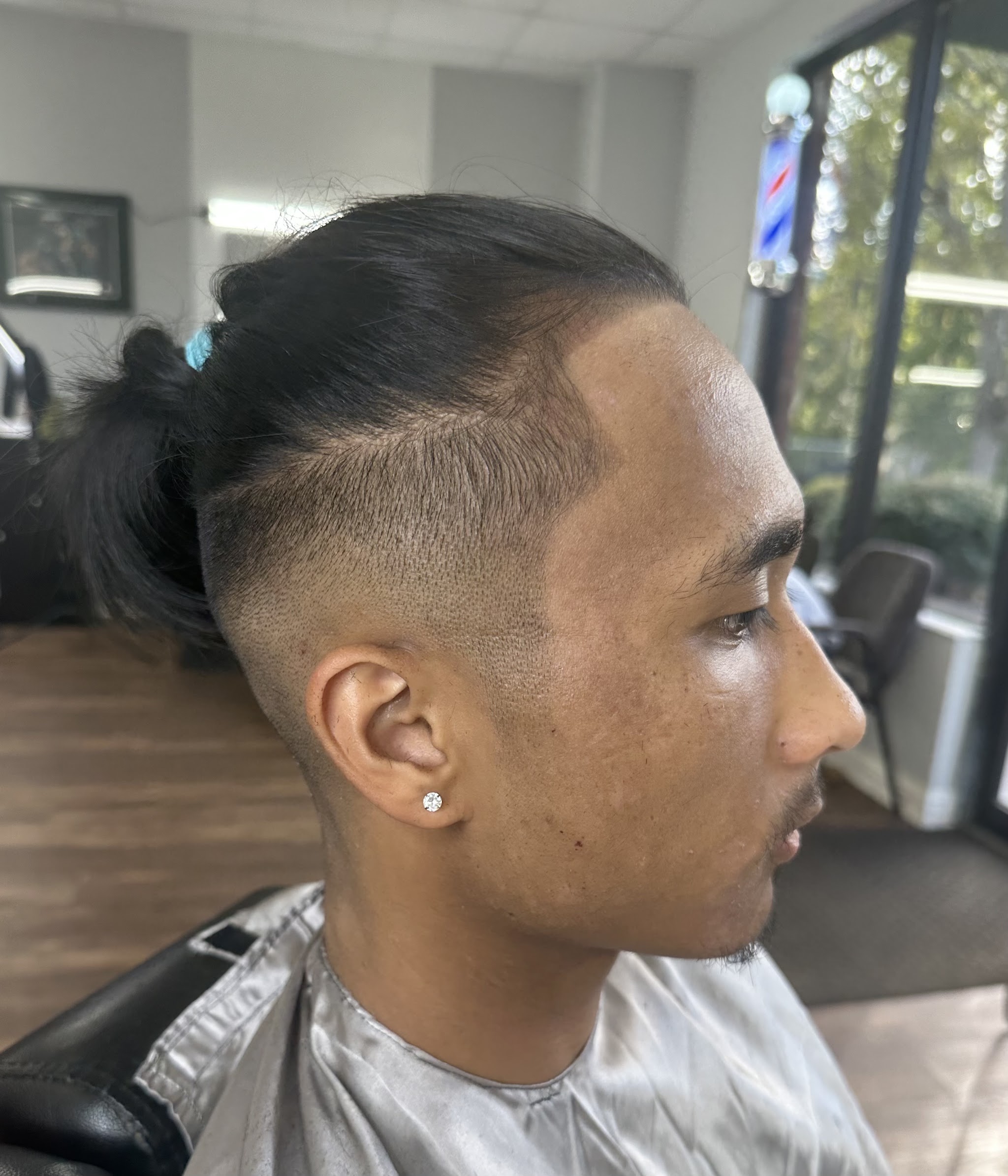 Undercut with a top knot and a clean taper